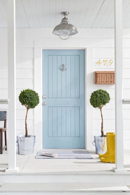 Puerta azul con fachada pintada de blanco