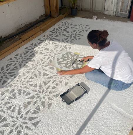 Gema pintando el suelo de la terraza con la plantilla