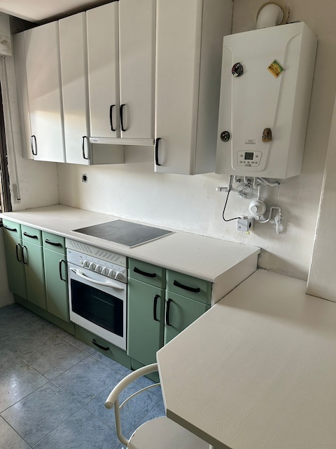 Cocina pintada en verde y blanco con encimera en blanco